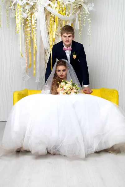Όμορφη νεαρή νύφη και τον γαμπρό ποζάρει στο studio — Φωτογραφία Αρχείου