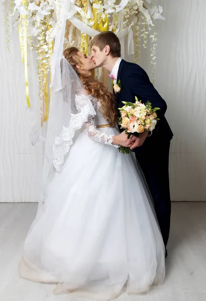 Beautiful young bride and groom posing at studio — Stock Photo, Image