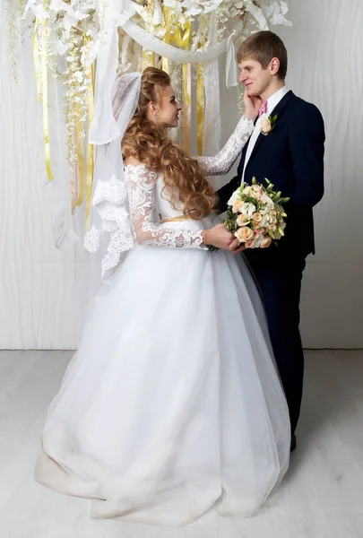 Beautiful young bride and groom posing at studio — Stock Photo, Image