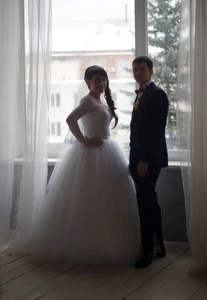 Όμορφη νεαρή νύφη και τον γαμπρό ποζάρει στο studio — Φωτογραφία Αρχείου