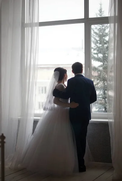 Beautiful young bride and groom posing at studio — Stock Photo, Image