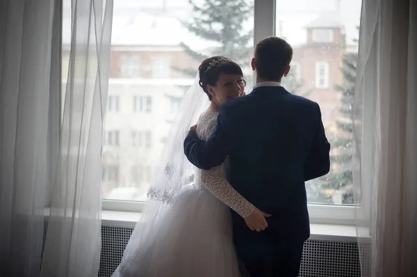 Beautiful young bride and groom posing at studio — Stock Photo, Image