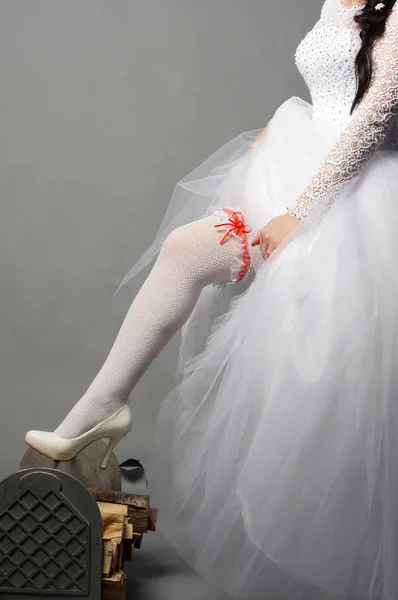 Beautiful young bride posing in a wedding dress at studio — Stock Photo, Image