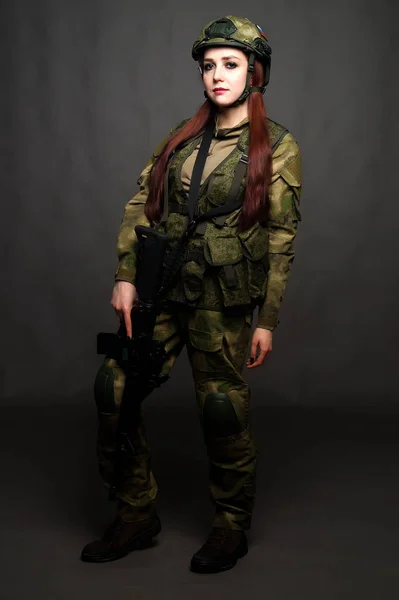 Ένα κορίτσι στρατιώτης με ρούχα καμουφλάζ ποζάρει σε ένα στούντιο. — Φωτογραφία Αρχείου