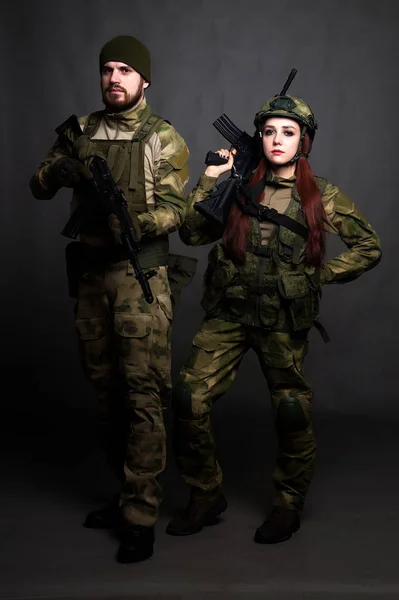 Twol soldiers in camouflage clothing poses in a Studio