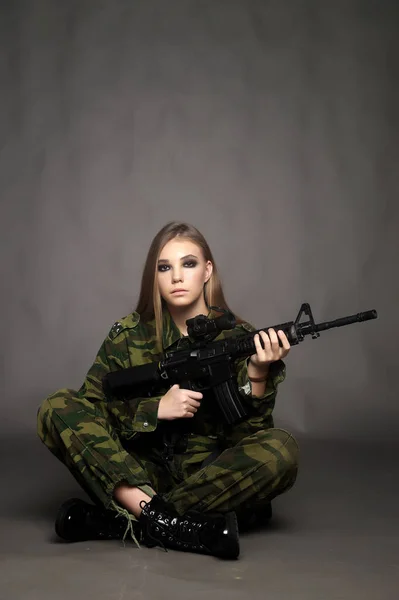 Eine Soldatin in Tarnkleidung posiert in einem Studio — Stockfoto