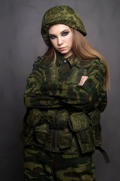 Ένα κορίτσι στρατιώτης με ρούχα καμουφλάζ ποζάρει σε ένα στούντιο. — Φωτογραφία Αρχείου