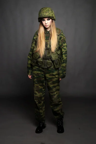 Une jeune fille soldat en tenue de camouflage pose dans un Studio — Photo