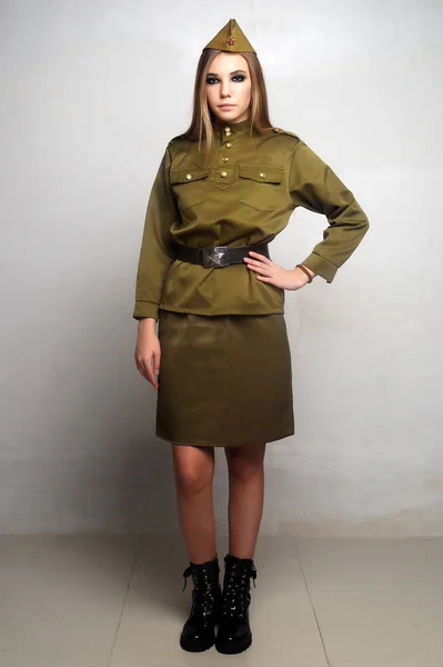 Una chica soldado vestida de camuflaje posa en un estudio — Foto de Stock