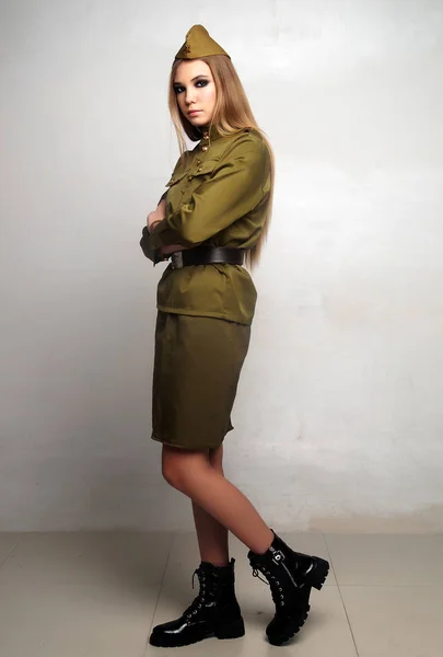 Una chica soldado vestida de camuflaje posa en un estudio — Foto de Stock