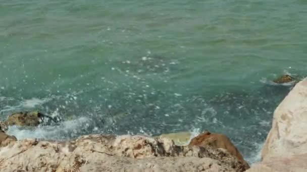 Las olas del mar se aplastan lentamente en la costa rocosa. cámara lenta 4K — Vídeo de stock