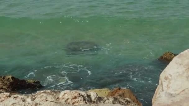 Las olas del mar se aplastan lentamente en la costa rocosa. cámara lenta 4K — Vídeo de stock