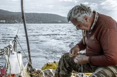 Sahilde balık tutan yaşlı kadın.