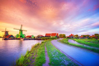 Hollanda yel değirmenleri ve nehir kıyısında günbatımı, Felemenk, Hollanda ile geleneksel köy.