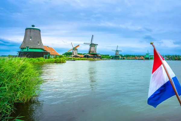 Traditioneel dorp met Nederlandse windmolens en rivier bij zonsondergang, Holland, Nederland. — Stockfoto