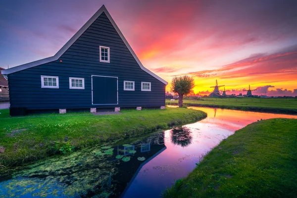 Traditional village at sunset, with dutch windmills, bridge and river on Zaanse Schans, Holland, Netherlands. — Stock Photo, Image