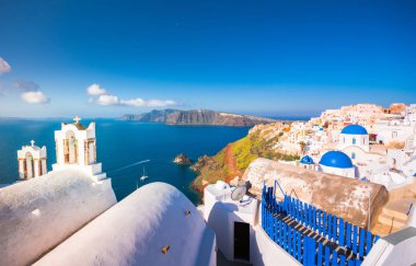 Yunanistan 'ın Santorini adasındaki Oia kasabası. Caldera, Ege denizi üzerinde mavi kubbeleri olan geleneksel ve ünlü evler ve kiliseler
