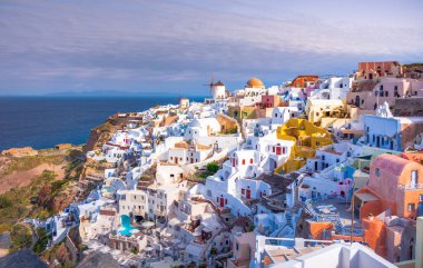 Yunanistan 'ın Santorini adasındaki Oia kasabası. Caldera, Ege denizi üzerinde mavi kubbeleri olan geleneksel ve ünlü evler ve kiliseler