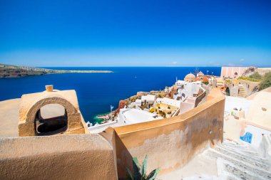 Yunanistan 'ın Santorini adasındaki Oia kasabası. Caldera, Ege denizi üzerinde mavi kubbeleri olan geleneksel ve ünlü evler ve kiliseler