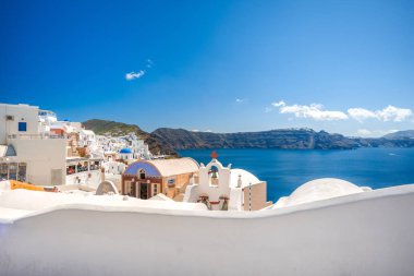 Yunanistan 'ın Santorini adasındaki Oia kasabası. Caldera, Ege denizi üzerinde mavi kubbeleri olan geleneksel ve ünlü evler ve kiliseler
