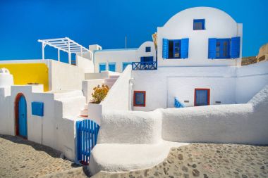 Yunanistan 'ın Santorini adasındaki Oia kasabası. Caldera, Ege denizi üzerinde mavi kubbeleri olan geleneksel ve ünlü evler ve kiliseler