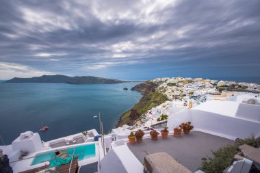 Yunanistan 'ın Santorini adasındaki Oia kasabası. Caldera, Ege denizi üzerinde mavi kubbeleri olan geleneksel ve ünlü evler ve kiliseler