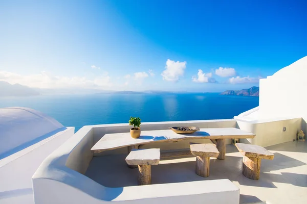 Hrnec s kytičkou a talíř na dřevěný stůl s pozadím oceánu, Santorini, Řecko — Stock fotografie