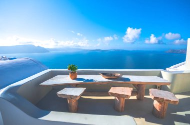 Çiçek ve okyanus arka plan, Santorini, Yunanistan ile ahşap bir masa bir tabağa potu