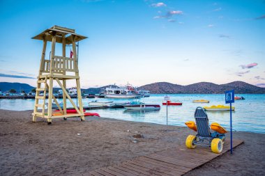 Cankurtaran Kulesi ile plaj tekerlekli sandalye için Engelli yüzücüler, Elounda, Crete, Yunanistan.