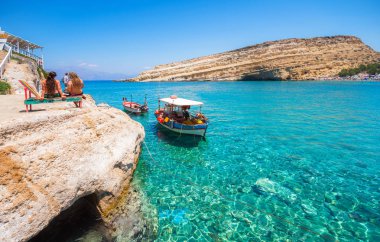 İki balıkçı tekneleri buzlu mağaralar ile Matala plajda.