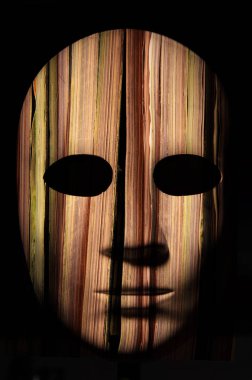 Yüzey, nötr ifade koyu arka plan üzerinde kırık kaba ahşap dokulu maskeyle boyalı.