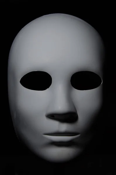 Nötr ifade ve gölgeler koyu arka plan üzerinde beyaz maske.
