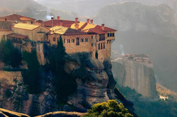 Vista del monasterio de Meteora Roussanou al atardecer, Grecia. Formaciones geológicas de grandes rocas con monasterios encima de ellas . — Foto de Stock