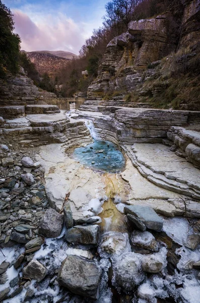 Kolymbithres Ovires buzul ile kışın. Küçük gölde doğal kayaların arasına iki en güzel köyleri Zagori bölgedeki Megalo (büyük) Papigo ve Mikro (küçük) Papigo, Yunanistan.