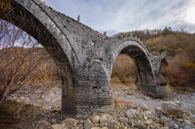 Eski Plakida - Kalogerikon Vikos Kanyon, Zagorohoria, Yunanistan taş köprüde kemerli. Kış günbatımı buz ve buzul Nehri üzerinde.