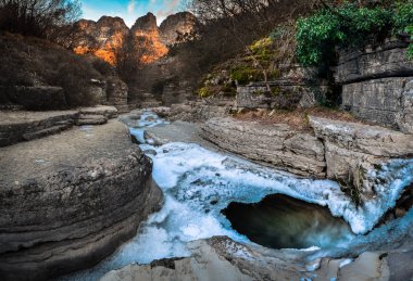 Kolymbithres Ovires buzul ile kışın. Küçük gölde doğal kayaların arasına iki en güzel köyleri Zagori bölgedeki Megalo (büyük) Papigo ve Mikro (küçük) Papigo, Yunanistan.