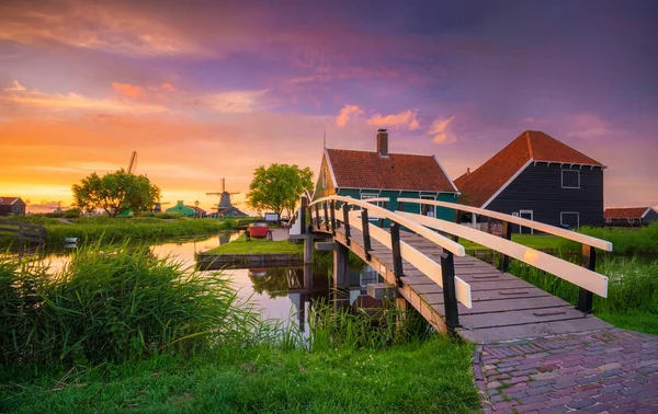 オランダ風車とオランダ、オランダ、夕暮れ時の川の伝統的な村. — ストック写真