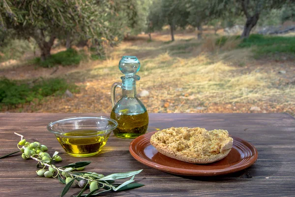 Kase ve sızma zeytinyağı, zeytin, zeytin ağacı ve Girit Rusk'ı dakos ahşap tablo, Girit, Yunanistan zeytin ağacına sahasında taze bir dalı ile şişe.