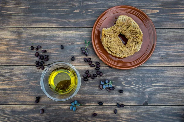Miska z oliwą z oliwek, oliwki, świeżych gałęzi drzewa oliwnego i kreteńskiej rusk dakos zamknąć na drewnianym stole, Kreta, Grecja. — Zdjęcie stockowe