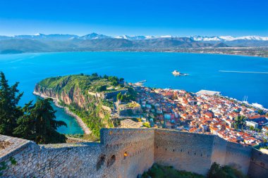 Old town of Nafplion in Greece view from above with tiled roofs, small port and bourtzi castle on the Mediterranean sea water clipart