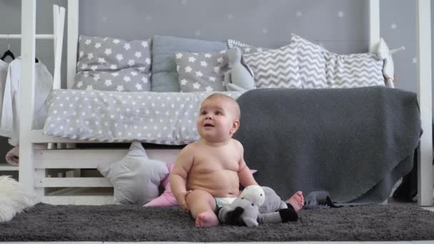 Het kind zit in de kinderkamer. Kijkt naar de camera — Stockvideo