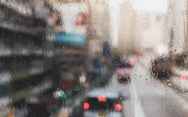 Blurred rain drop on the Bus glass,Urban view of rain drops fall