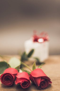 Sevgililer günü hediye kutusu ve kırmızı gül ahşap tablo rustik tarzı üzerinde arka plan