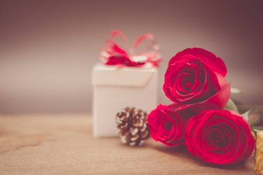 Sevgililer günü hediye kutusu ve kırmızı gül ahşap tablo rustik tarzı üzerinde arka plan