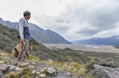 Yeni Zelanda'nın en uzun buzulun başladığı Tasman Buzulu bakış açısı ve buz terminal göle Aoraki buluştuğu alt ulaşır bir adama / Mount Cook Milli Parkı