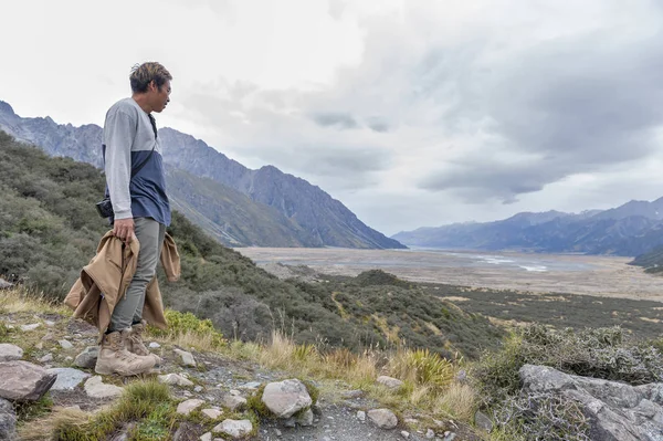 Yeni Zelanda'nın en uzun buzulun başladığı Tasman Buzulu bakış açısı ve buz terminal göle Aoraki buluştuğu alt ulaşır bir adama / Mount Cook Milli Parkı