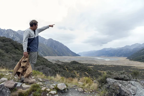 A man at Tasman Glacier viewpoint where New Zealand's longest glacier begins and the lower reaches where the ice meets the terminal lake, Aoraki / Mount Cook National Park — Stock Photo, Image