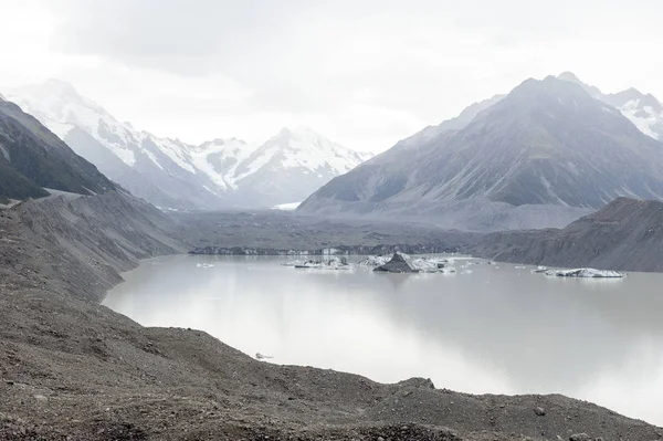一个男人在塔斯曼冰川观新西兰最长的冰川的开始位置和下游冰交汇终端湖，库克 / 库克山国家公园 — 图库照片