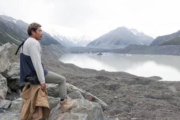 Yeni Zelanda'nın en uzun buzulun başladığı Tasman Buzulu bakış açısı ve buz terminal göle Aoraki buluştuğu alt ulaşır bir adama / Mount Cook Milli Parkı