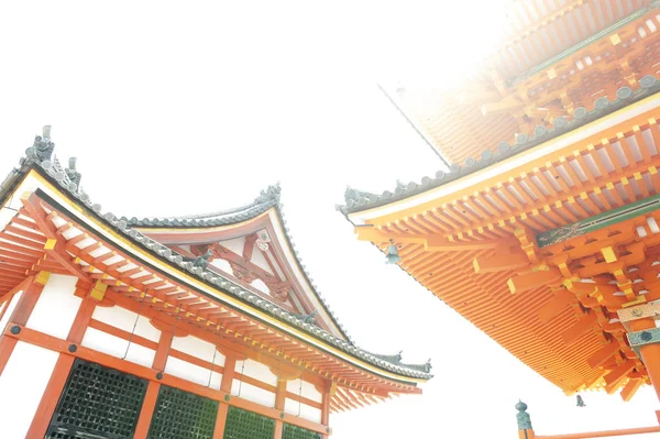 Low angle view of Japanese architecture buildings and roof details of pagoda against white sky at a Buddhist temple in Kyoto, Japan — Stock Photo, Image